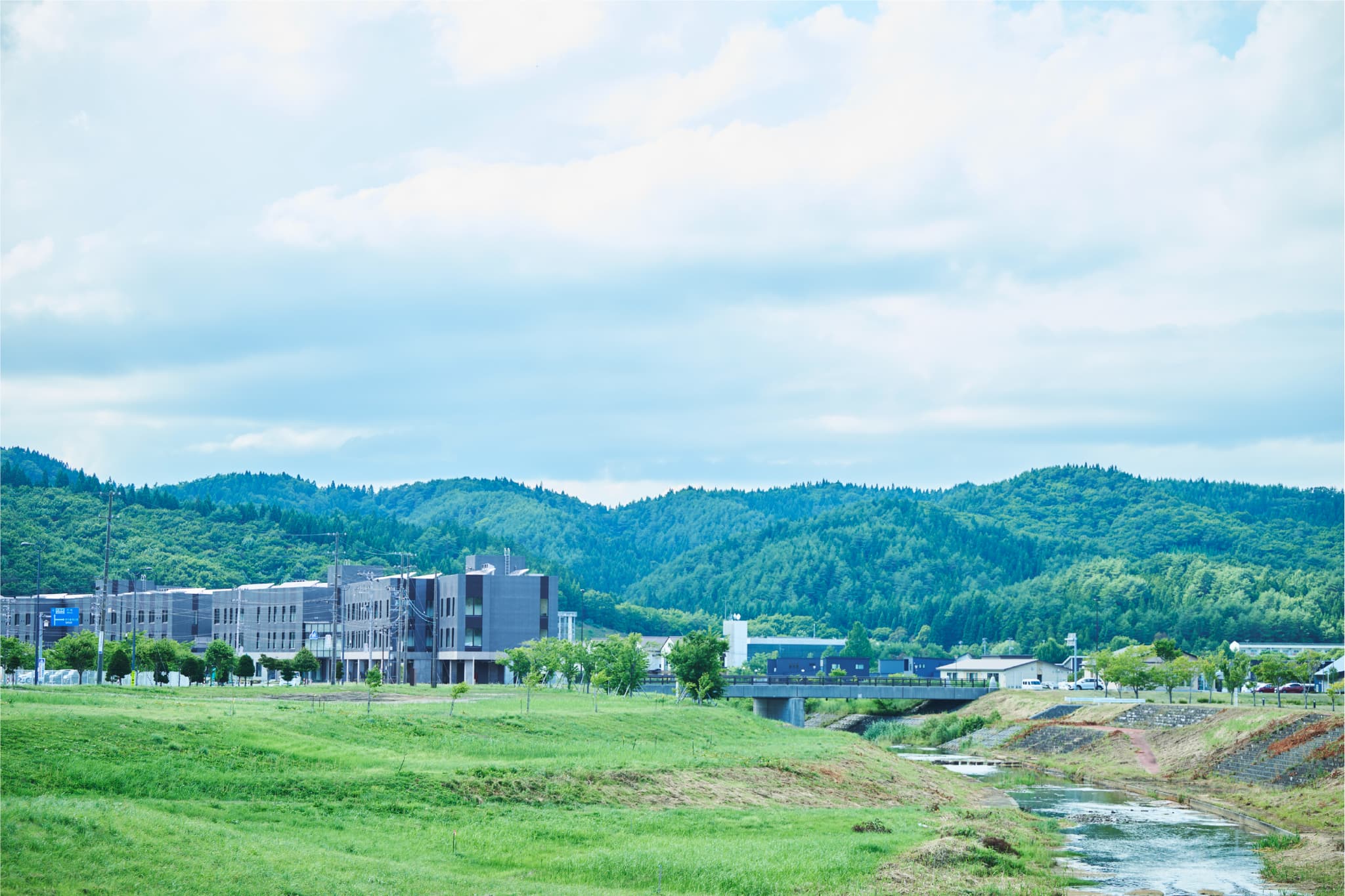 青空と山々を背景にした施設の風景