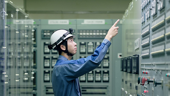 制御室で制御盤を確認する作業員のようす